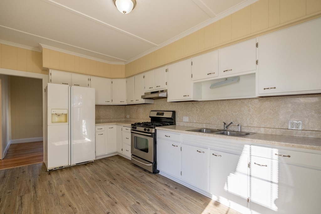 268 Locust Street Fall River, MA 02720 - Photo 11 of 38 a kitchen with stainless steel appliances granite countertop a stove a sink and white cabinets