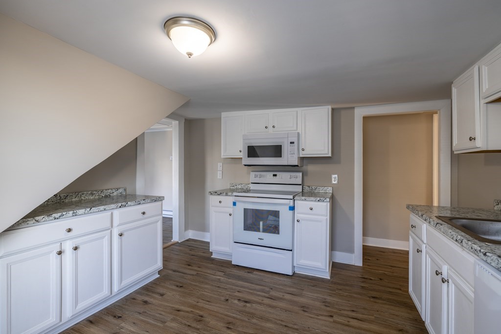 268 Locust Street Fall River, MA 02720 - Photo 28 of 38 a kitchen with granite countertop white cabinets and white appliances