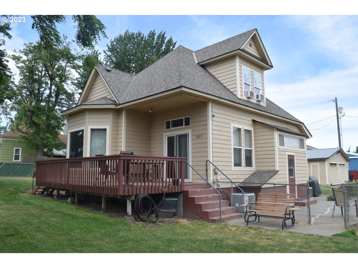 a view of a house with wooden deck and furniture