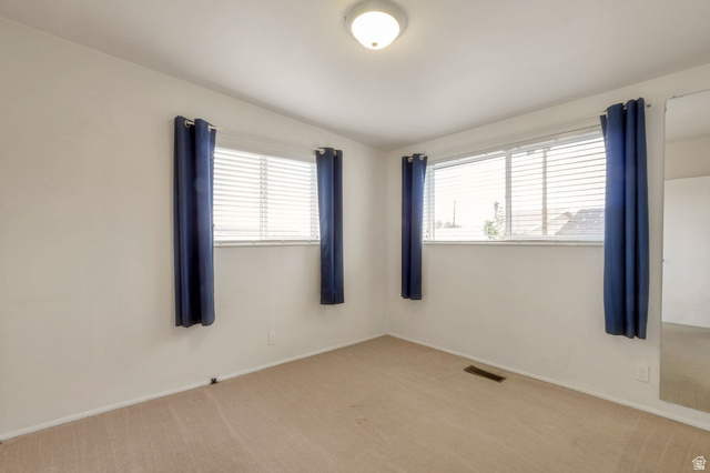 447 550 South Bountiful, UT 84010 - Photo 7 of 25 Bright room featuring two windows with horizontal blinds, a ceiling-mounted light fixture, and carpeted flooring