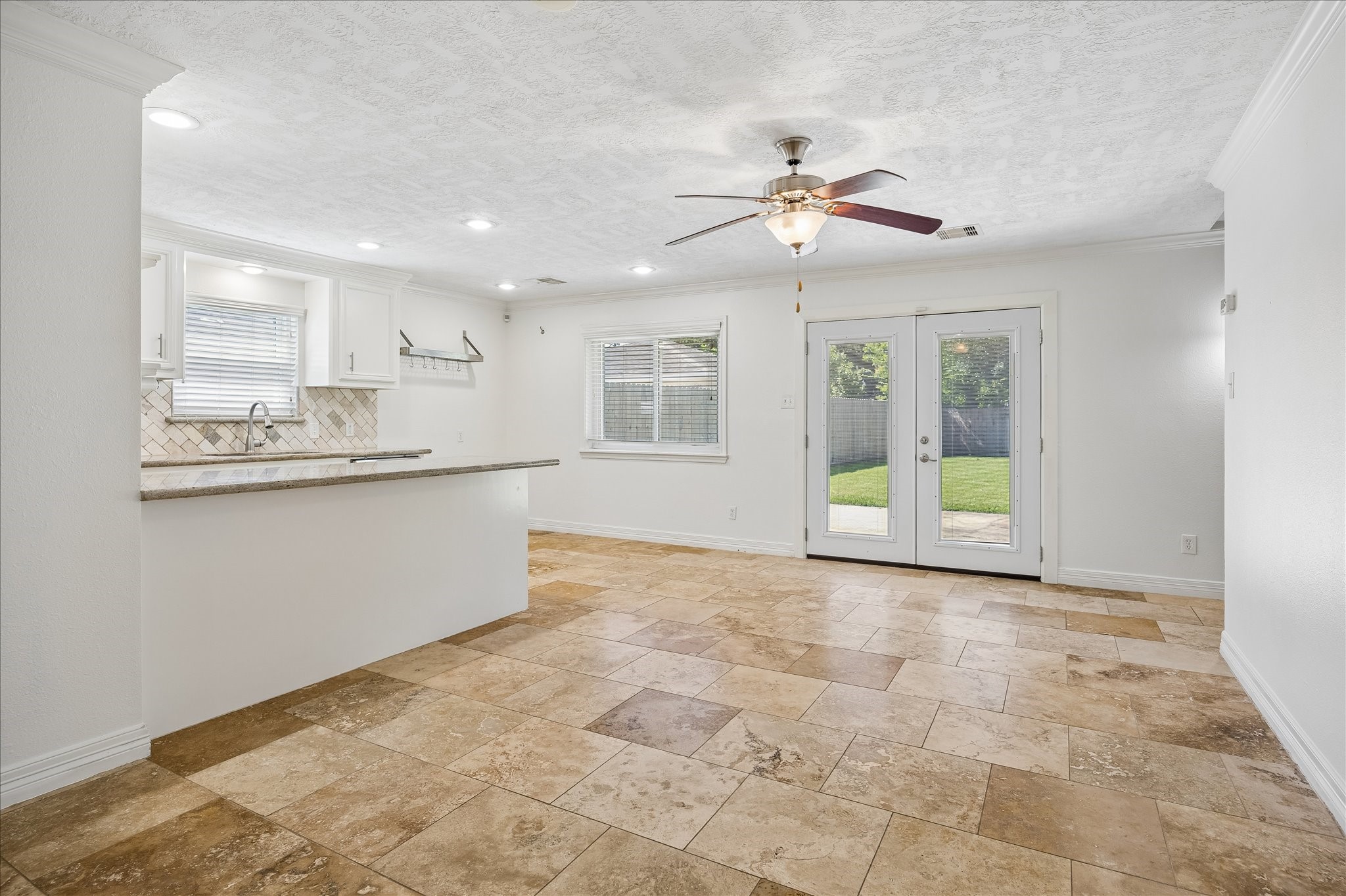 5019 Kinglet Street Houston, TX 77035 - Photo 7 of 24 Living room is open to kitchen, offering the perfect setting for entertaining. Double doors leading to back yard offer wonderful green views. Crown molding, recessed lighting & ceiling fan round out this welcoming space!