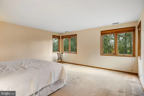 a large bed sitting in a bedroom next to a window