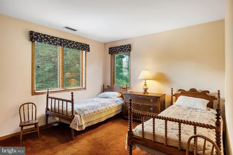 a bedroom with a bed chair and window