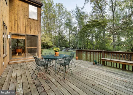 a view of a roof deck with table and chairs and wooden floor