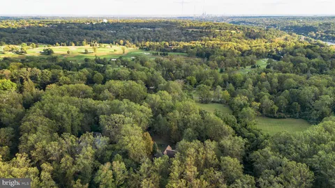 an aerial view of a houses with a lush green hillside
