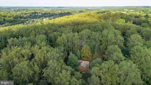 an aerial view of residential houses with outdoor space and trees
