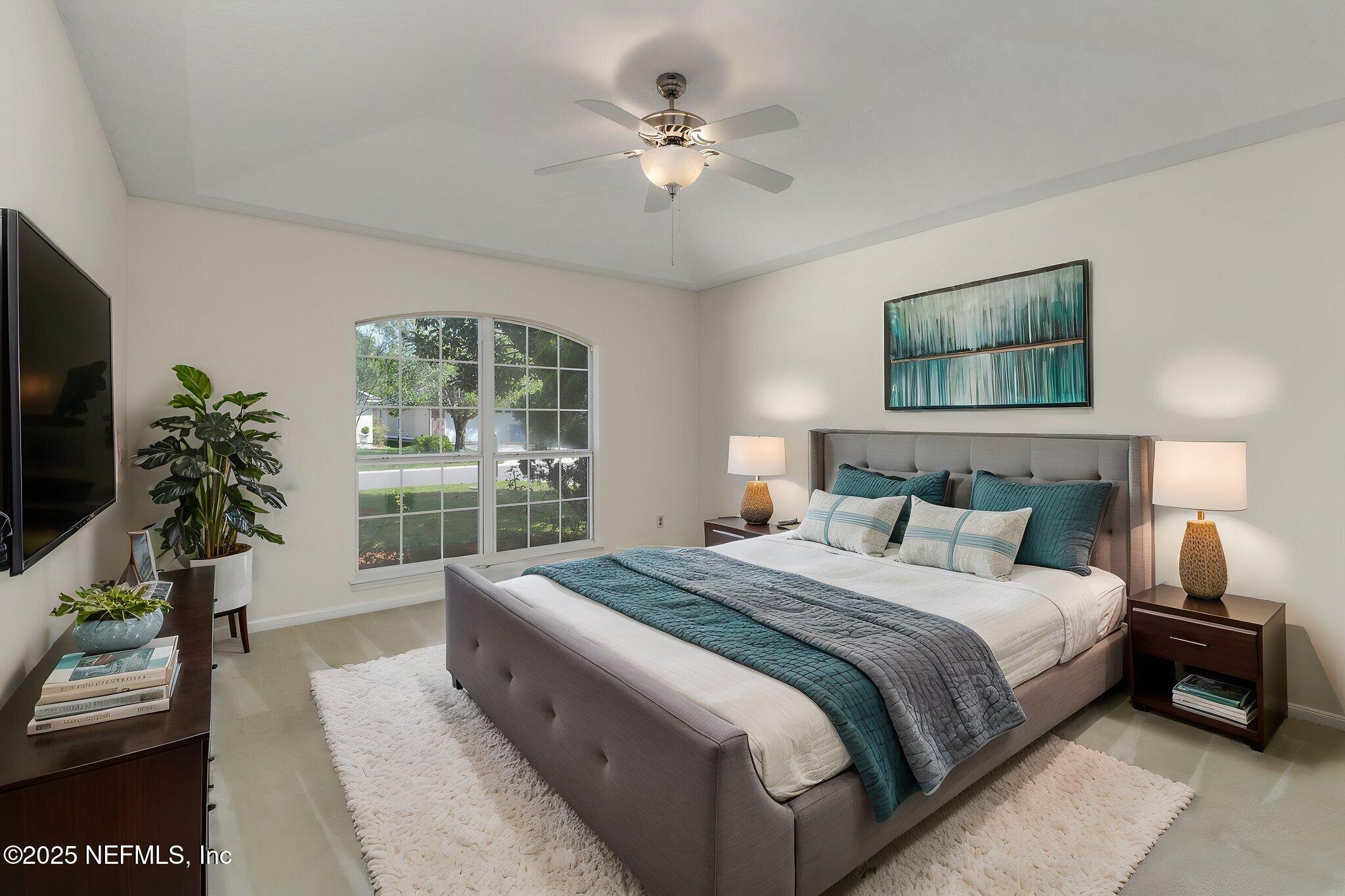 844 MacKenzie Circle St. Augustine, FL 32092 - Photo 17 of 40 a bedroom with a large bed and a chandelier fan