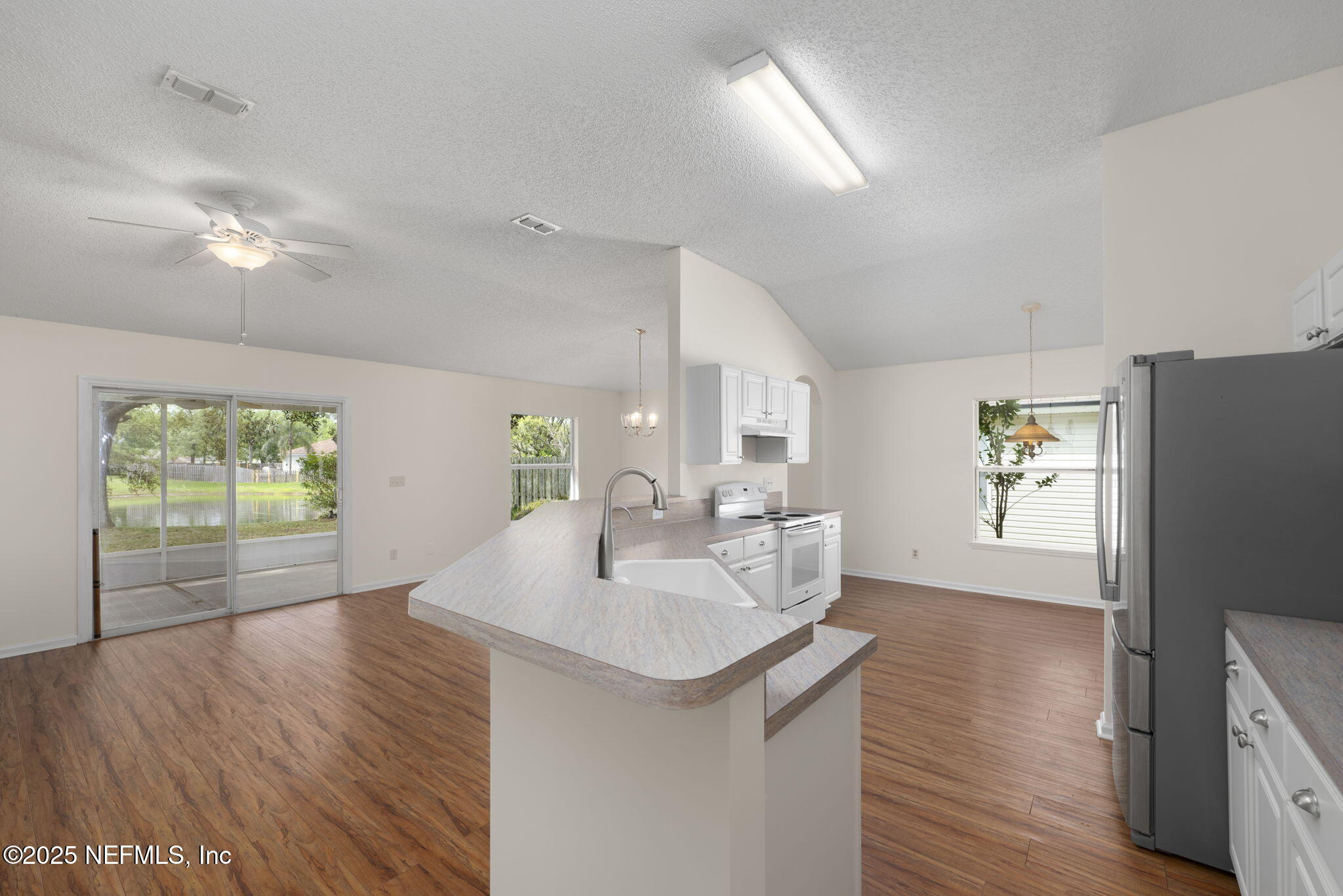 844 MacKenzie Circle St. Augustine, FL 32092 - Photo 7 of 40 a kitchen with stainless steel appliances granite countertop a sink a stove a refrigerator and island with wooden floor