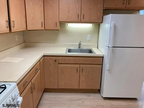 a kitchen with a refrigerator sink and cabinets