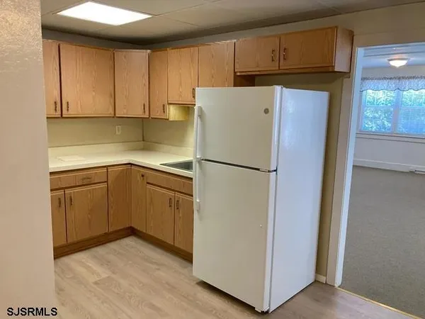a kitchen with a refrigerator sink and cabinets