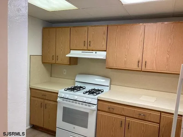 a kitchen with granite countertop cabinets appliances and a sink