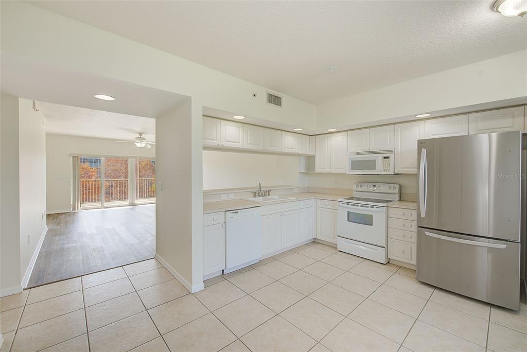 960 Starkey Road, Unit 3302 Largo, FL 33771 - Photo 3 of 28 a kitchen with white cabinets and white appliances