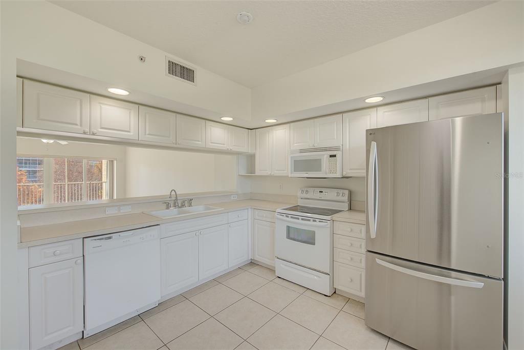 960 Starkey Road, Unit 3302 Largo, FL 33771 - Photo 4 of 28 a kitchen with white cabinets and white appliances