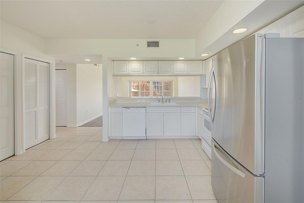960 Starkey Road, Unit 3302 Largo, FL 33771 - Photo 5 of 28 a view of a refrigerator in kitchen and white cabinets