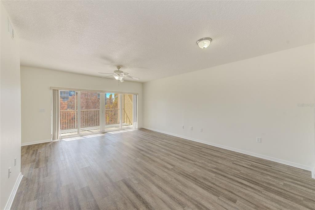 960 Starkey Road, Unit 3302 Largo, FL 33771 - Photo 7 of 28 wooden floor in an empty room with a window