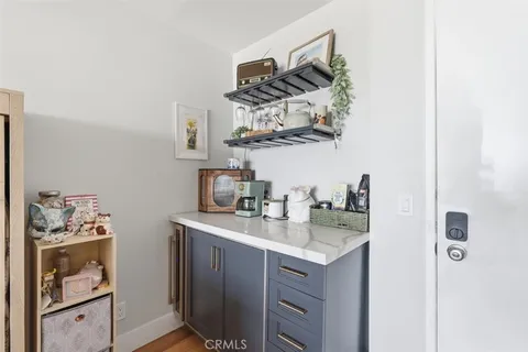 a kitchen with stainless steel appliances a refrigerator a sink a stove and white cabinets with wooden floor