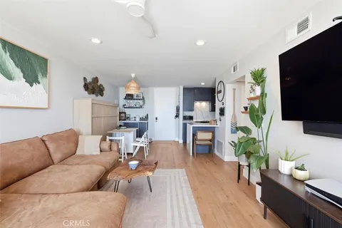 a living room with furniture and a dining table with wooden floor