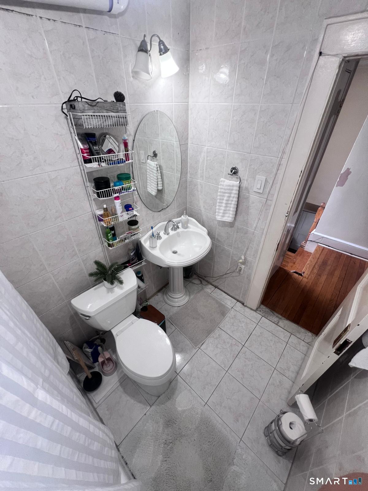3461 East Main Street Bridgeport, CT 06606 - Photo 19 of 68 a bathroom with a sink toilet and a mirror