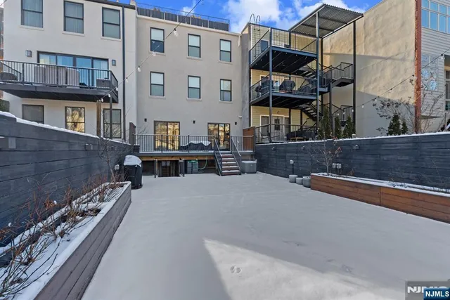a view of kitchen with stainless steel appliances granite countertop a stove top oven a sink a dining table and chairs