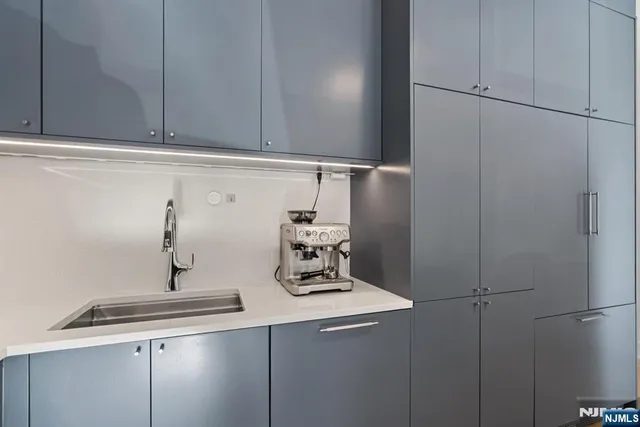 a kitchen with granite countertop a dining table chairs and a refrigerator