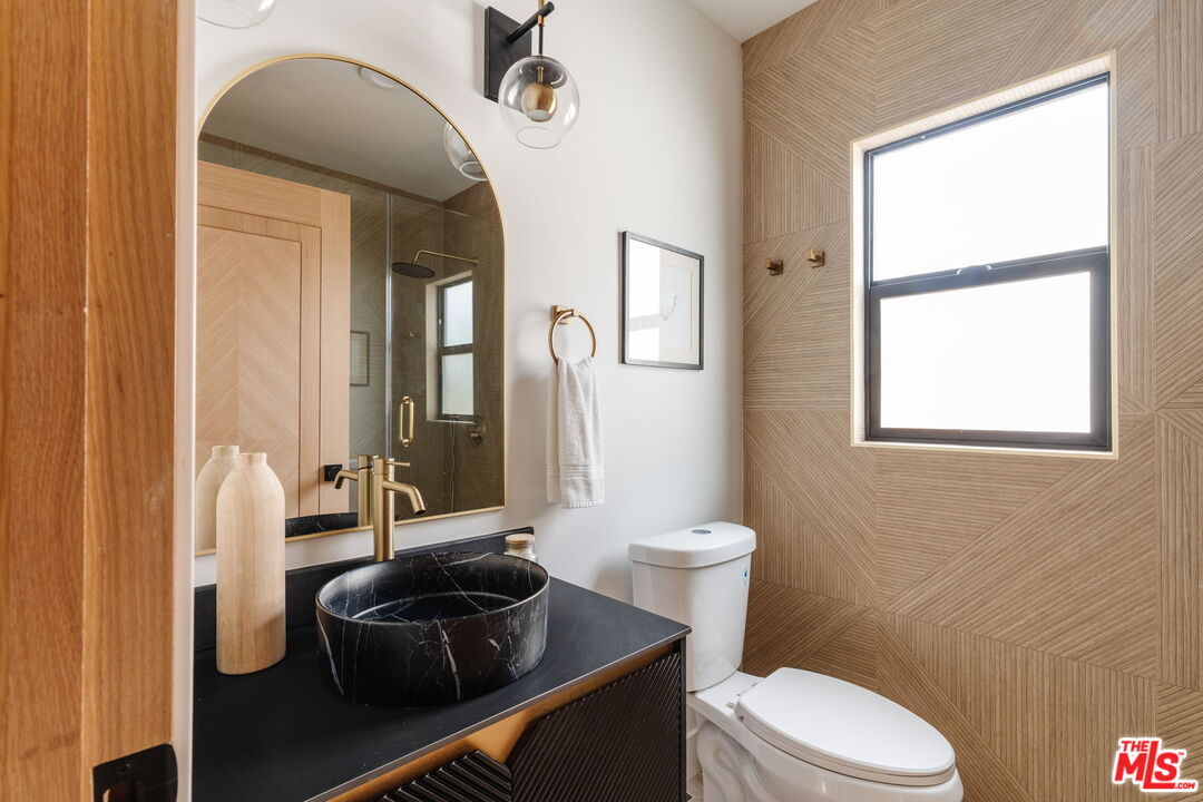 5168 Southridge Avenue Los Angeles, CA 90043 - Photo 44 of 74 a bathroom with a toilet a sink and a mirror