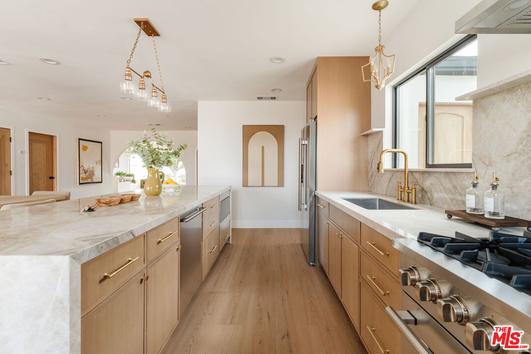 5168 Southridge Avenue Los Angeles, CA 90043 - Photo 7 of 74 a large kitchen with kitchen island a stove a sink a dining table and chairs