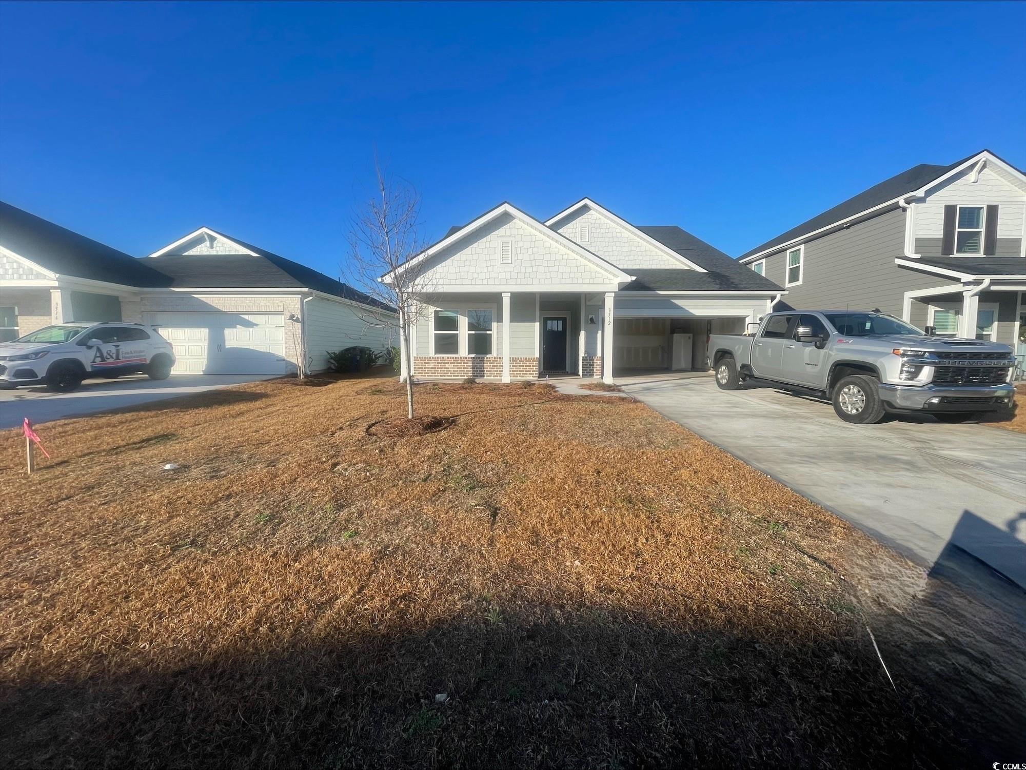 View of front of property featuring concrete driveway and an attached garage
