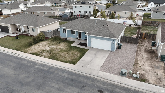 1437 925 South Vernal, UT 84078 - Photo 45 of 47 Single-story residence featuring a light blue exterior, attached garage with a white door, and a gray shingle roof