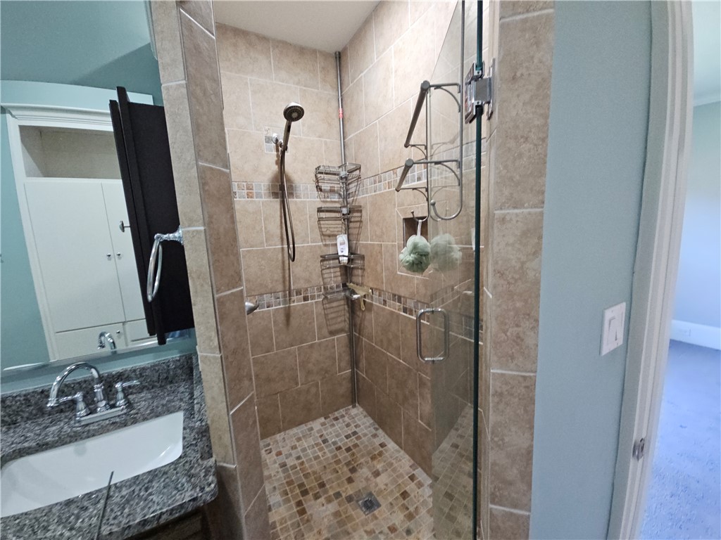 208 Pendleton Street Pickens, SC 29671 - Photo 14 of 30 This primary bathroom offers a convenient walk-in shower with tile flooring and a spacious vanity.