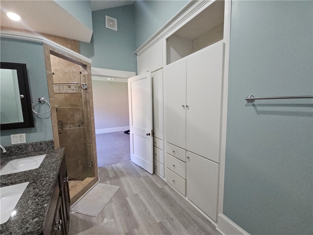 208 Pendleton Street Pickens, SC 29671 - Photo 16 of 30 This primary bathroom features a double vanity and a glass-enclosed shower, offering both comfort and functionality.