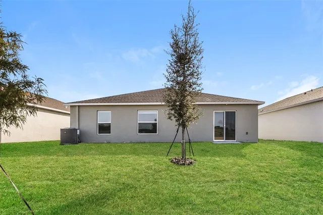a front view of house with yard and tree