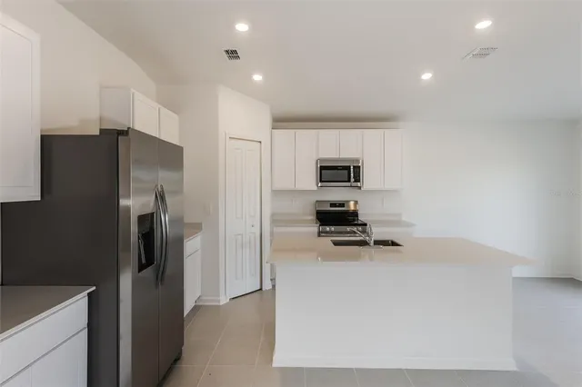a kitchen that has a refrigerator a stove and a sink