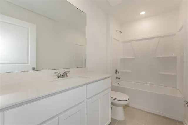 a bathroom with a granite countertop sink a toilet and shower