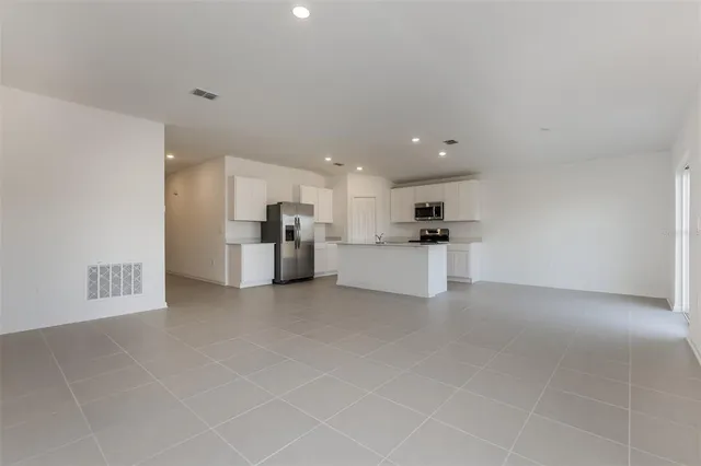 a view of a kitchen with refrigerator and white cabinets