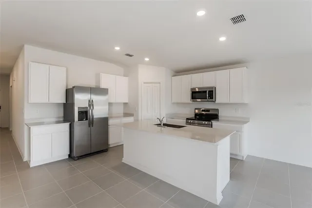 a kitchen with stainless steel appliances a refrigerator stove microwave and sink