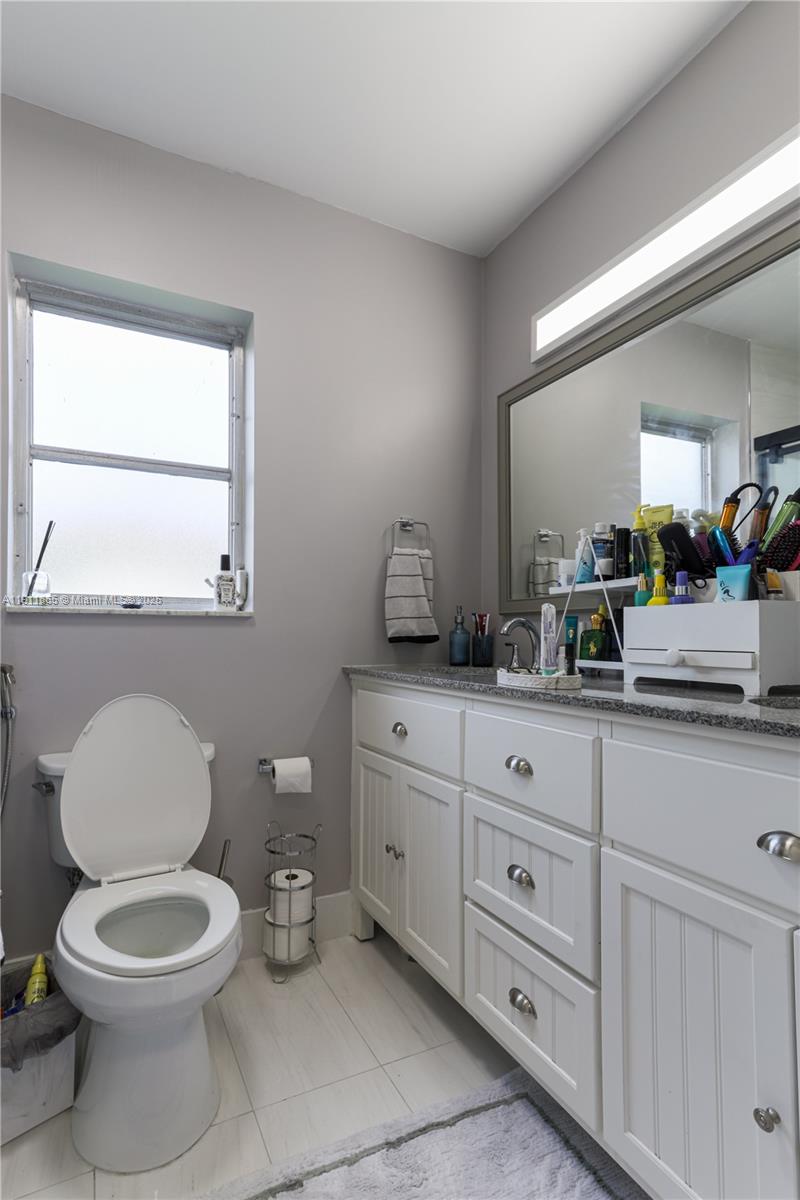 7940 Northwest 9th Street Margate, FL 33063 - Photo 17 of 21 a bathroom with a toilet a sink and mirror