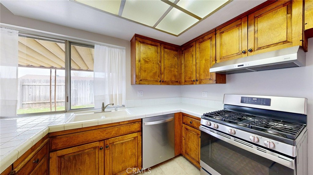 3415 Valencia Hill Drive Riverside, CA 92507 - Photo 19 of 48 a kitchen with stainless steel appliances granite countertop a sink a stove and a window
