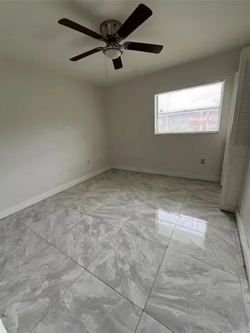 a view of a big room with wooden floor and windows
