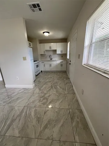 a big room with chandelier fan and windows