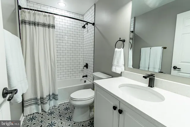 a house with porch with wooden floor potted plants and floor to ceiling window
