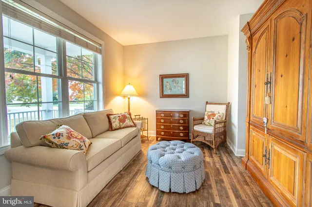 a view of a hallway with wooden floor and windows
