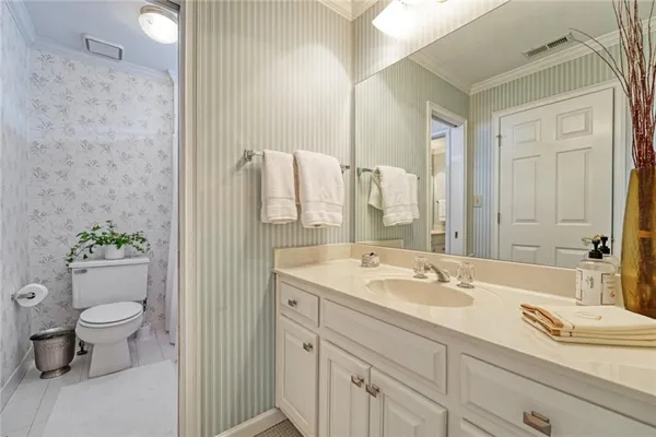 a bathroom with a granite countertop sink a toilet and a mirror