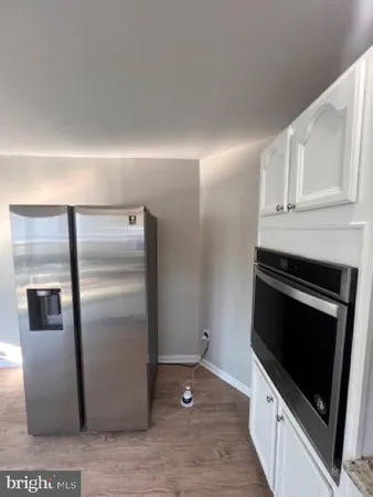 a kitchen with metallic refrigerator and cabinets