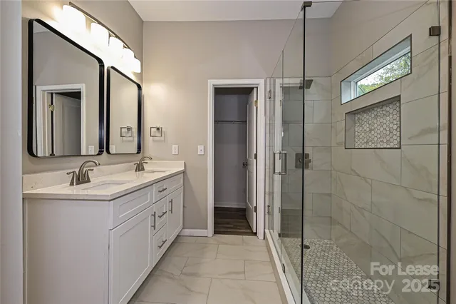 a bathroom with a double vanity sink mirror and shower