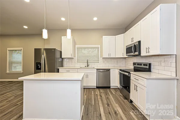 a kitchen with a stove a sink and a refrigerator