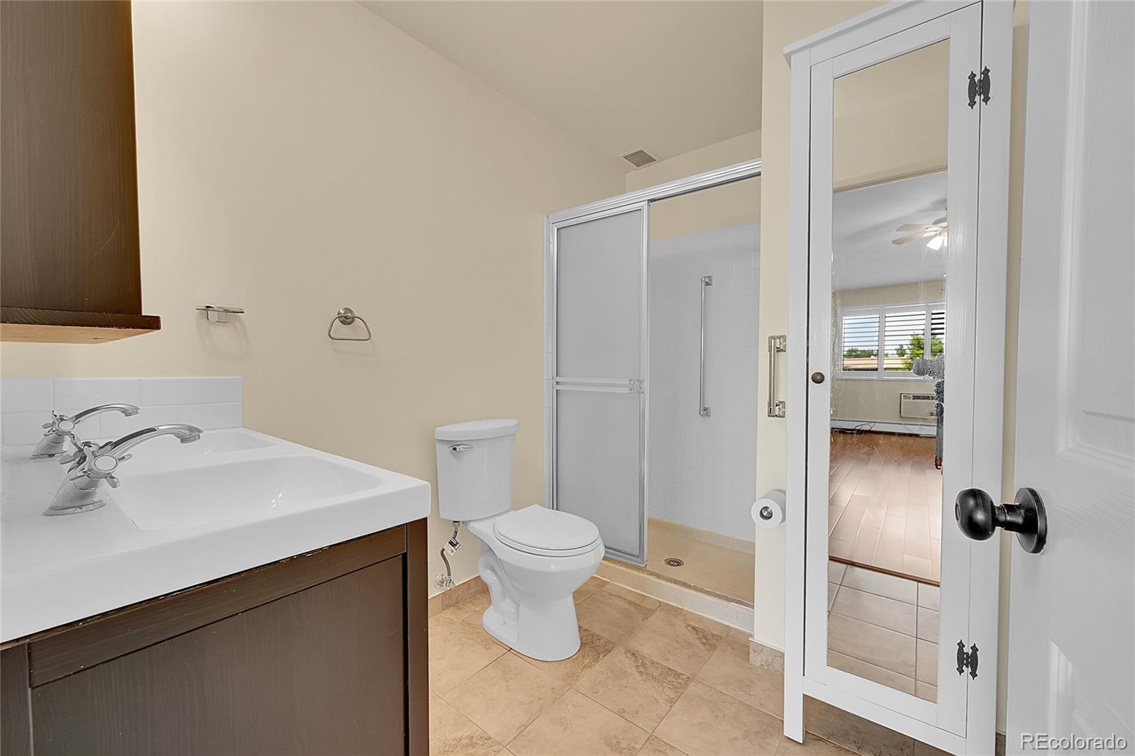 645 South Alton Way, Unit 9D Denver, CO 80247 - Photo 12 of 29 a bathroom with a sink toilet and shower