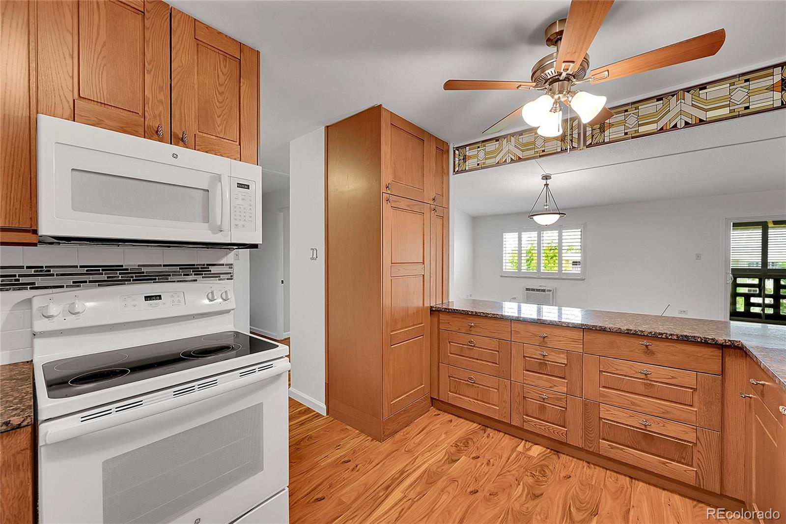 645 South Alton Way, Unit 9D Denver, CO 80247 - Photo 19 of 29 a kitchen with stainless steel appliances granite countertop a stove and a microwave