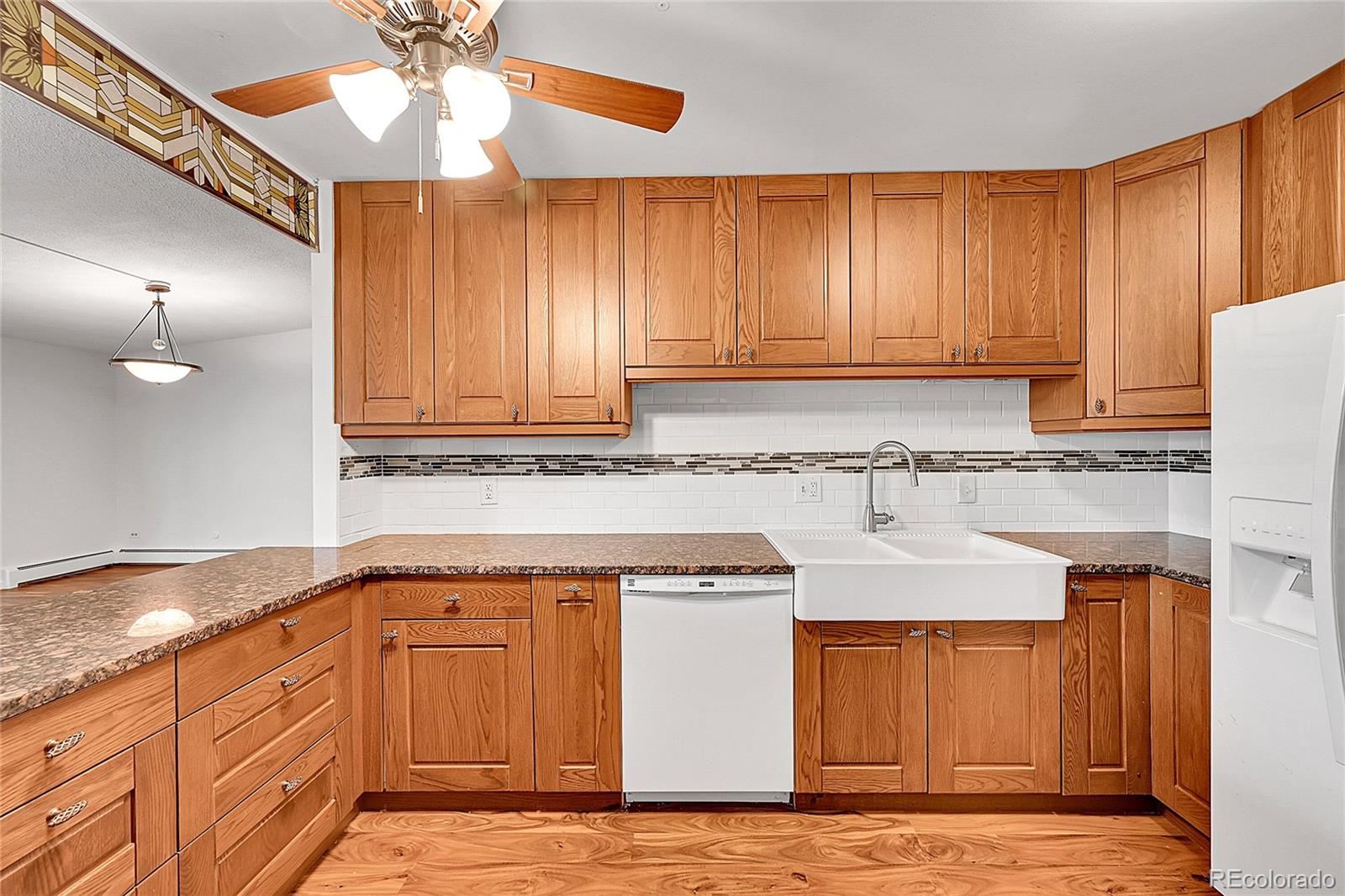 645 South Alton Way, Unit 9D Denver, CO 80247 - Photo 21 of 29 a kitchen with granite countertop a stove a sink and a microwave oven with cabinets