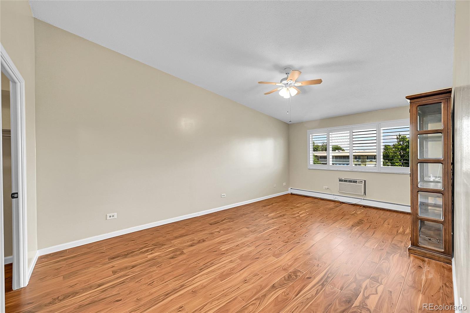 645 South Alton Way, Unit 9D Denver, CO 80247 - Photo 8 of 29 wooden floor in an empty room with a window