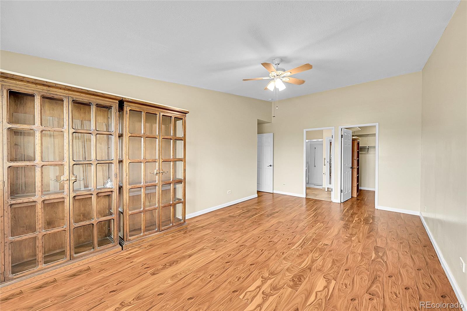 645 South Alton Way, Unit 9D Denver, CO 80247 - Photo 9 of 29 a view of empty room with wooden floor and fan